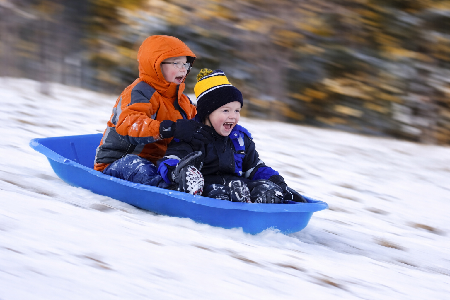 Family sledding and snow tubing on a winter hill in Warrensburg, New York